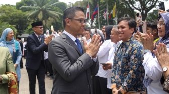 Menteri Luar Negeri Arrmanatha Nasir (kanan) bersama Pejabat lama Menteri Luar Negeri Sugiono (kiri) didampingi istri menyapa pegawai Kementerian Luar Negeri dalam acara pisah sambut pejabat baru dan lama di Gedung Pancasila, Kementerian Luar Negeri, Jakarta, Senin (12/10/2026). [Suara.com/Alfian Winanto]