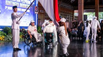 Atlet National Paralympic Committee (NPC) Indonesia mencium bendera Merah Putih saat Pengukuhan dan Pelepasan Kontingen Indonesia Asian Para Games 2026 di Balai Kota Solo, Jawa Tengah, Senin (12/10/2026). [ANTARA FOTO/Mohammad Ayudha/wsj]