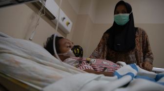 Orang tua dari pasien anak penderita infeksi saluran pernapasan akut (ISPA) menunggu anaknya yang menjalani perawatan di Rumah Sakit Umum Daerah (RSUD) BARI Palembang, Sumatera Selatan, Selasa (13/10/2026). [ANTARA FOTO/Nova Wahyudi/nz]
