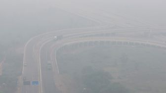 Sejumlah kendaraan melintas di simpang susun Jalan Tol Trans Sumatera (JTTS) ruas Palembang-Lampung yang tertutup kabut asap di Desa Ibul Besar III, Pemulutan, Ogan Ilir (OI), Sumatera Selatan, Selasa (13/10/2026). [ANTARA FOTO/Nova Wahyudi/tom]