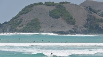 Sejumlah wisatawan bermain selancar di Pantai Tanjung Aan, Kawasan Ekonomi Khusus (KEK) Mandalika, Lombok Tengah, NTB, Selasa (13/10/2026). [ANTARA FOTO/Fikri Yusuf/tom]