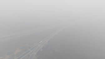 Sejumlah kendaraan melintas di simpang susun Jalan Tol Trans Sumatera (JTTS) ruas Palembang-Lampung yang tertutup kabut asap di Desa Ibul Besar III, Pemulutan, Ogan Ilir (OI), Sumatera Selatan, Selasa (13/10/2026). [ANTARA FOTO/Nova Wahyudi/tom]