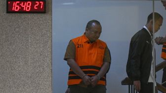 Tenaga ahli Kepala BNPB, Richard Erlangga (kiri), berjalan mengenakan rompi tahanan seusai menjalani pemeriksaan di Gedung Merah Putih KPK, Jakarta, Rabu (14/10/2026). [ANTARA FOTO/Fauzan/kye]