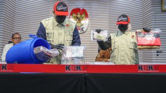 Petugas menunjukan barang bukti dari dalam tong dari kasus OTT Bupati Klaten Hamenang Wajar Ismoyo saat konferensi pers di Gedung Merah Putih KPK, Jakarta, Jumat (16/10/2026). [Suara.com/Alfian Winanto]
