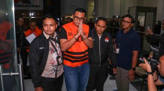 Bupati Klaten Hamenang Wajar Ismoyo (tengah) berjalan menggunakan rompi tahanan usai menjalani pemeriksaan di Gedung Merah Putih KPK, Jakarta, Jumat (16/10/2026). [Suara.com/Alfian Winanto]
