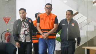 Bupati Klaten Hamenang Wajar Ismoyo (tengah) berjalan menggunakan rompi tahanan usai menjalani pemeriksaan di Gedung Merah Putih KPK, Jakarta, Jumat (16/10/2026). [Suara.com/Alfian Winanto]
