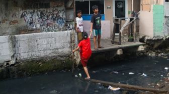 Warga beraktivitas di bantaran Anak Kali Krukut, kawasan Kebon Melati, Tanah Abang, Jakarta, Senin (19/10/2026). [Suara.com/Alfian Winanto]