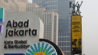 Sejumlah aktifis Greenpeace membentangkan spanduk yang bertema krisis iklim di Bundaran HI, Jakarta, Selasa (20/10/2026). [Suara.com/Alfian Winanto]

