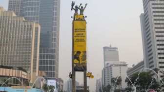 Sejumlah aktifis Greenpeace membentangkan spanduk yang bertema krisis iklim di Bundaran HI, Jakarta, Selasa (20/10/2026). [Suara.com/Alfian Winanto]

