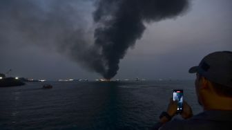 Warga memotret Kapal Motor Penumpang (KMP) Batumandi yang terbakar di perairan Pelabuhan Merak, Kota Cilegon, Banten, Selasa (20/10/2026Kapal Motor Penumpang (KMP) Batumandi yang terbakar di perairan Pelabuhan Merak, Kota Cilegon, Banten, Selasa (20/10/2026). [ANTARA FOTO/Rikardo/pma/nym]