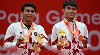 Pebulu tangkis ganda putra Indonesia Muh Al Imran (kanan) dan Suryo Nugroho (kiri) menunjukkan medali emasnya usai mengalahkan pasangan Korea Selatan Shin Kyung Hwan dan Cho Nadan pada final ganda putra SL3-SU5 Asian Para Games 2026 di Municipal Gymnasium, Ichinomiya, Nagoya, Jepang, Jumat (23/10/2026). [ANTARA FOTO/M Risyal Hidayat/nz]