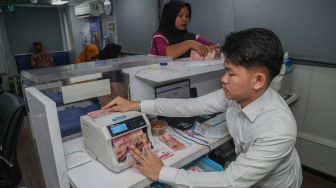 Petugas BRI menghitung uang milik warga di atas Kapal Teras Bahtera Seva II saat pelayananan perbankan di Desa Bajo Sangkuang, Kecamatan Botang Lomang, Kabupaten Halmahera Selatan, Maluku Utara, Senin (26/10/2026). [ANTARA FOTO/Andri Saputra/agr]