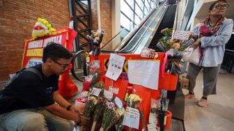 Seorang penumpang kereta melakukan aksi di depan bunga duka cita sebagai bentuk protes atas kerusakan eskalator di Sky Bridge Stasiun Bojonggede, Kabupaten Bogor, Jawa Barat, Rabu (28/10/2026). [ANTARA FOTO/ Yulius Satria Wijaya/kye]

