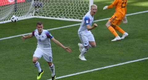 Striker Islandia, Alfred Finnbogason (kiri) merayakan golnya ke gawang Argentina di laga kualifikasi Grup D Piala Dunia 2018, Sabtu (16/6). [AFP/Francisco Leong]