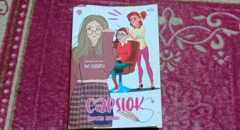 Duka di Balik Komedi, Ulasan Novel Capslok: Capster Anjlok