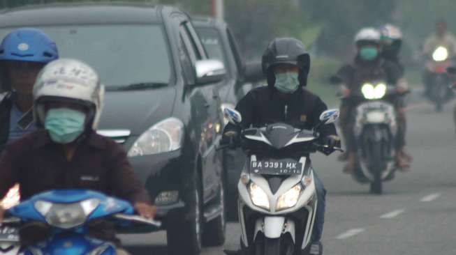 Pengendara menggunakan masker saat melintas di jalan Adinegoro, Padang, Sumbar, Senin (10/3). BMKG Ketaping Sumbar melaporkan jarak pandang pada sejumlah wilayah di provinsi itu pada Senin pagi (10/3). [Antara/Iggoy el Fitra]