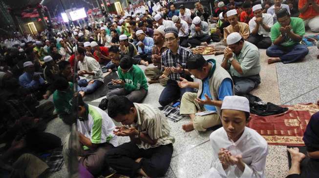 Shalat untuk para penumpang pesawat Malaysia Airlines MH370 yang hilang, di Bandara Internasional Kuala Lumpur, Sepang (13/3). [Reuters/Edgar Su]