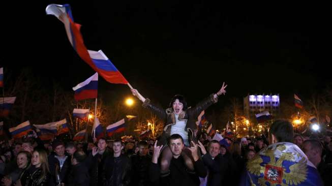 Warga Krimea merayakan hasil pemungutan suara dalam referendum Krimea, di Lenin Square, Simferopol, Minggu (16/3). [Reuters/Baz Ratner ]