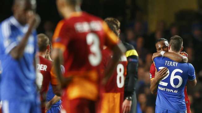 Pemain Galatasaray Didier Drogba berpelukan dengan John Terry usai laga leg ke dua babak 16 besar Liga Champions antara timnya dengan Chelsea di Stamford Bridge, London [19/3]. [Reuters/Eddie Keogh]