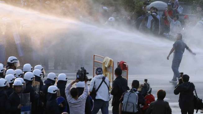 Polisi mengunakan water cannon untuk membubarkan aksi unjuk rasa menolak pakta perdagangan dengan Cina, di Taipei, Taiwan, Senin (24/3). [Reuters/Edward Lau] 