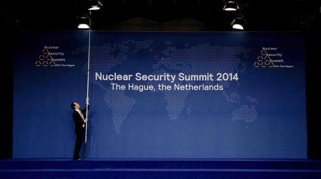 Panitia memperbaiki posisi lampu diatas panggung, sebelum para kepala negara berfoto bersama di Nuclear Security Summit di Hague, Selasa (25/3). [Reuters/Robin Van Lonkhuijsen]