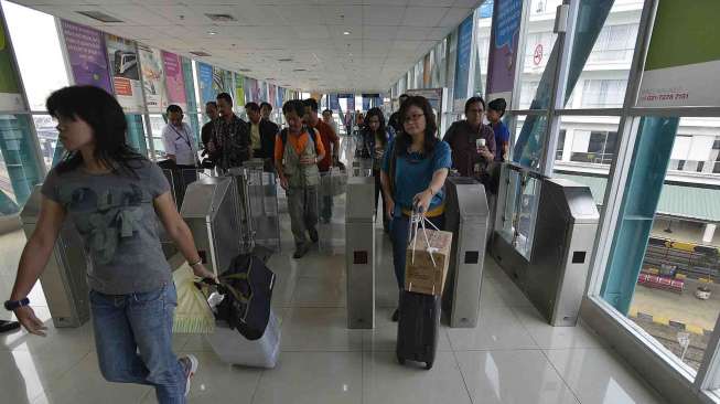 Sejumlah calon penumpang berjalan menuju peron kereta api yang akan menuju Bandara Internasional Kualanamu di Stasiun Besar Kereta Api Indonesia (KAI) Medan, Sumut, Kamis (27/3). [Antara/Widodo S. Jusuf]