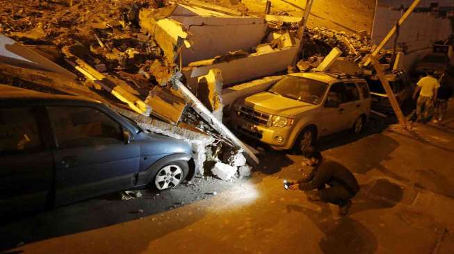 Juru kamera mengambil gambar setelah gempa dan tsunami mengguncang Iquique, Chile, Rabu (2/4). [Reuters/Ivan Alvarado]