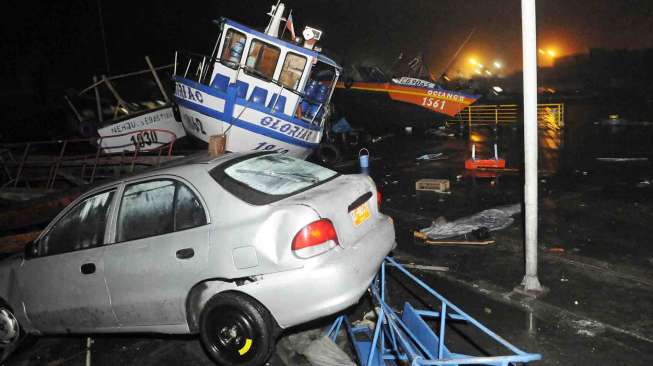 Perahu dan mobil tersapu ke atas dermaga setelah diterjang tsunami di pelabuhan Iquique, Chile, Rabu (2/4). [Reuters/Cristian Vivero]