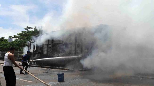 Sebuah Bus Transjakarta jurusan Pulogadung - Dukuh Atas terbakar di Jalan Sultan Agung, Jakarta, Selasa (8/4). [suara.com/Adrian Mahakam]