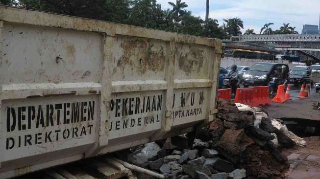 Jalan Jenderal Sudirman Amblas, Jakarta, Kamis (10/4). Jalan yang amblas tersebut mengakibatkan lubang yang besar berdiameter dua setengah meter dan dalam serta belum diketahui penyebabnya. [suara.com/Bernard Chaniago]