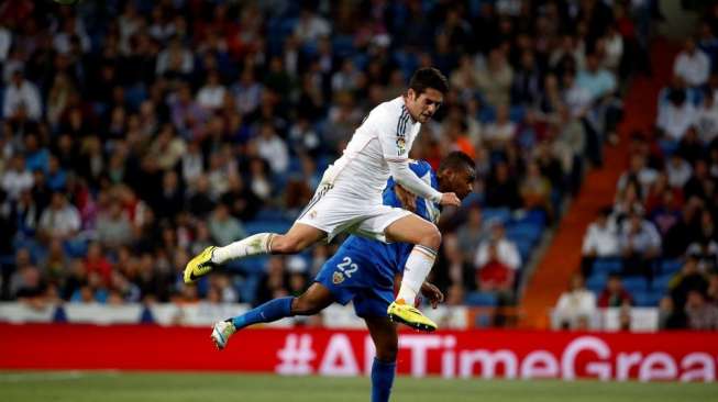 Isco berebut bola di udara dengan pemain Almeria dalam laga La Liga di Santiago Bernabeu, (13/4). (Reuters/Susana Vera)