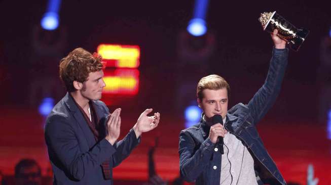 Aktor Sam Claflin (kiri) dan  Josh Hutcherson meraih penghargaan Best Movie of The Year di MTV Video Award 2014, di Los Angeles, California, Minggu (13/4). [Reuters/Danny Moloshok]