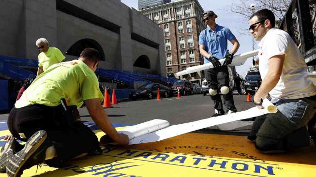 Pekerja menyiapkan garis finish lomba lari maraton di Boylston Street, Boston, Massachusetts, Senin (14/4). [Reuters/Dominick Reuter] 