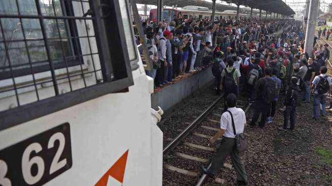 Ratusan penumpang KRL Commuter Line berunjukrasa dengan menahan kereta Argo Parahyangan yang melintas di stasiun Bekasi, Kamis (17/4). [Antara/Paramayuda]