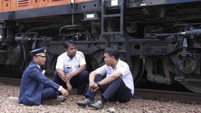 Masinis kereta Argo Parahyangan duduk di samping lokomotif di stasiun Bekasi, Kamis (17/4). [Antara/Paramayuda]