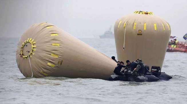 Tim penyelamat memasang balon apung di lokasi tenggelamnya kapal feri Sewol di perairan Korea Selatan, Jumat (18/4). [Reuters/Yonhap]