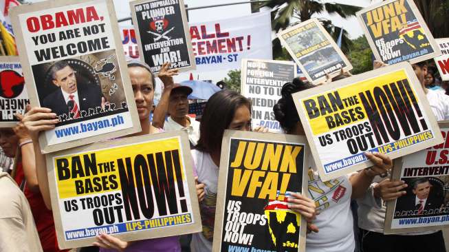 Demonstran mengusung poster menentang kedatangan Presiden Amerika Serikat Barack Obama di depan Kedubes Amerika Serikat di Manila, Filipina, (23/4). (Reuters/Romeo Ranoco)