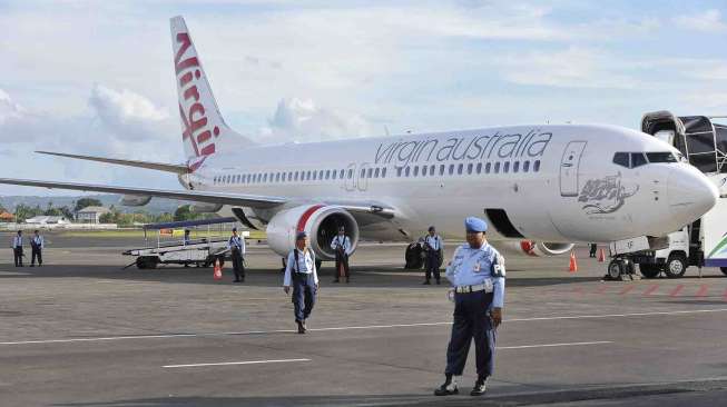 Personel TNI AU berjaga di samping pesawat Virgin Australia di Bandara Ngurah Rai, Denpasar, Jumat (25/4). [Antara/Nyoman Budhiana]