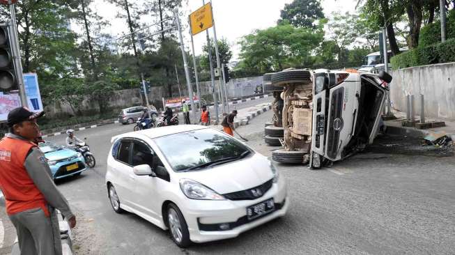 Truk pengaduk semen terguling di pertigaan setelah terowongan Jalan Jenderal Sudirman menuju Dukuh Atas Jakarta, Sabtu (26/4). [suara.com/Adrian Mahakam]