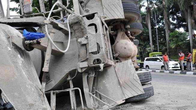 Truk pengaduk semen terguling di pertigaan setelah terowongan Jalan Jenderal Sudirman menuju Dukuh Atas Jakarta, Sabtu (26/4). [suara.com/Adrian Mahakam]