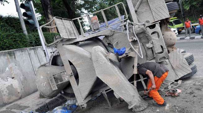 Truk pengaduk semen terguling di pertigaan setelah terowongan Jalan Jenderal Sudirman menuju Dukuh Atas Jakarta, Sabtu (26/4). [suara.com/Adrian Mahakam]