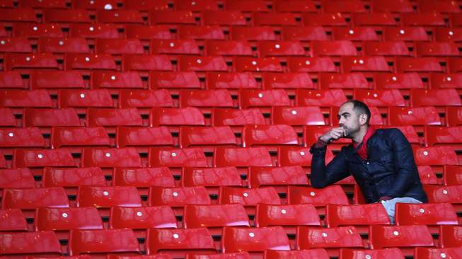 Seorang fans Liverpool duduk termenung sendirian usai kemenangan Chelsea di Anfield [Reuters/Darren Staples]