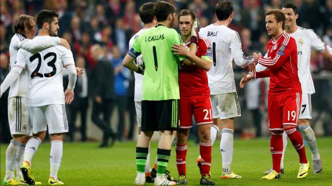 Kiper Real Madrid, Iker Casillas, memeluk kapten Bayern Munich, Philipp Lahm (tengah), usai leg kedua semifinal Liga Champions, Selasa (29/4/2014). [Reuters/Michaela Rehle]