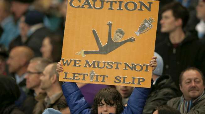 Seorang anak yang merupakan suporter Manchester City mengangkat poster sebelum kick off pertandingan melawan Aston Villa di Etihad Stadium. (Reuters/Phil Noble) 
