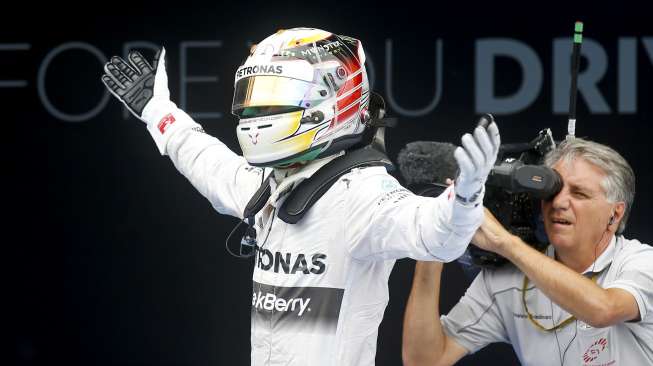 Pebalap Mercedes Lewis Hamilton usai merampungkan balap F1 di Catalunya, Spanyol, (11/5). Ini merupakan kemenangan keempat Hamilton musim ini secara berturut-turut. (Reuters/Albert Gea)