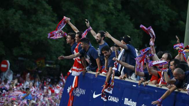 Para pemain Atletico Madrid melakukan parade keberhasilan mereka menjuara La Liga dengan bus tanpa dan mereka menyapa para pendukungnya ketika mereka tiba di Neptuno fountain. (Reuters/Juan Medina) 