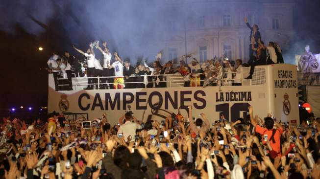 Para pemain Real Madrid dengan mobil bus atas terbuka disambut para suporter setelah tiba di ibukota Spanyol usai menjadi juara Liga Champions.(Reuters/Andrea Comas)   