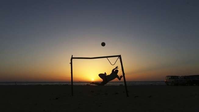 Seorang bocah bermain bola di pantai di Benghaji, beberapa waktu lalu. [Reuters/Esam Omran Al-Fetori]