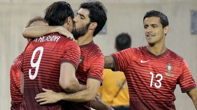 Striker Portugal mendapat ciuman dari rekannya, Luis Neto, usai membobol gawang Irlandia. Dalam laga ujicoba Samba 2014 ini, Portugal tekuk Irlandia 5-1. ( REUTERS/Ray Stubblebine)