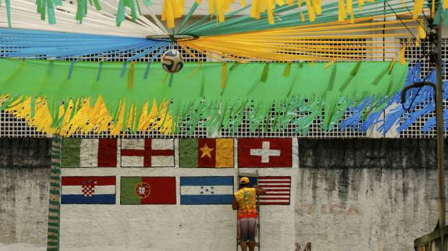 Seorang pekerja sedang mengecat negara peserta yang ambil bagian di Piala Dunia 2014 di stadion Arena Amazonia di Manaus. (Reuters/Siphiwe Sibeko)  